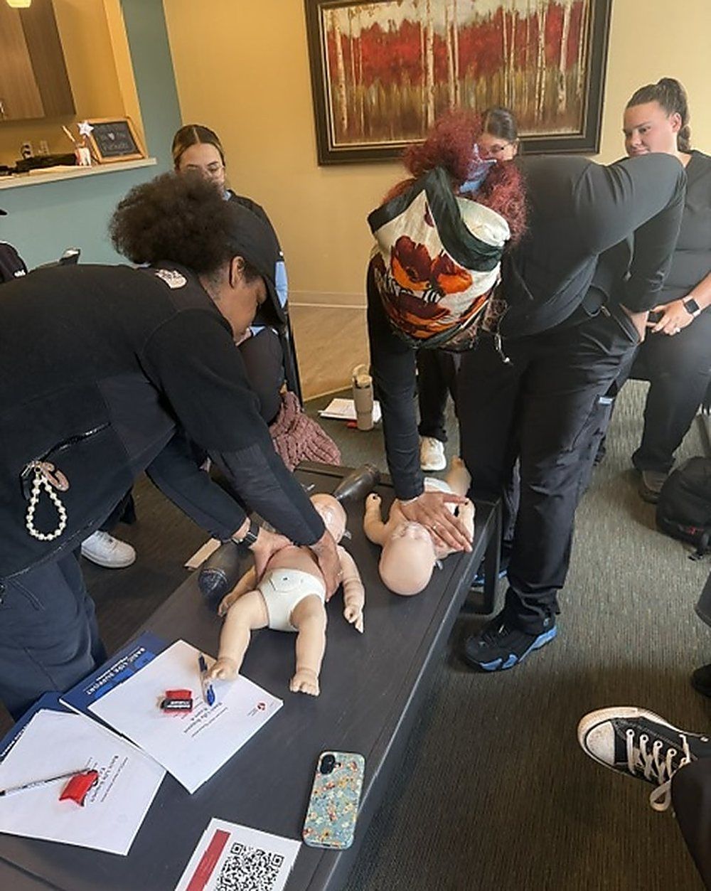 Clinical staff practicing infant CPR on manikins