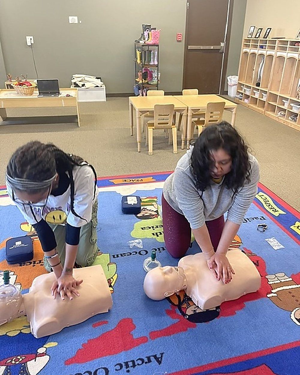 Childcare staff practicing chest compressions during a certification class