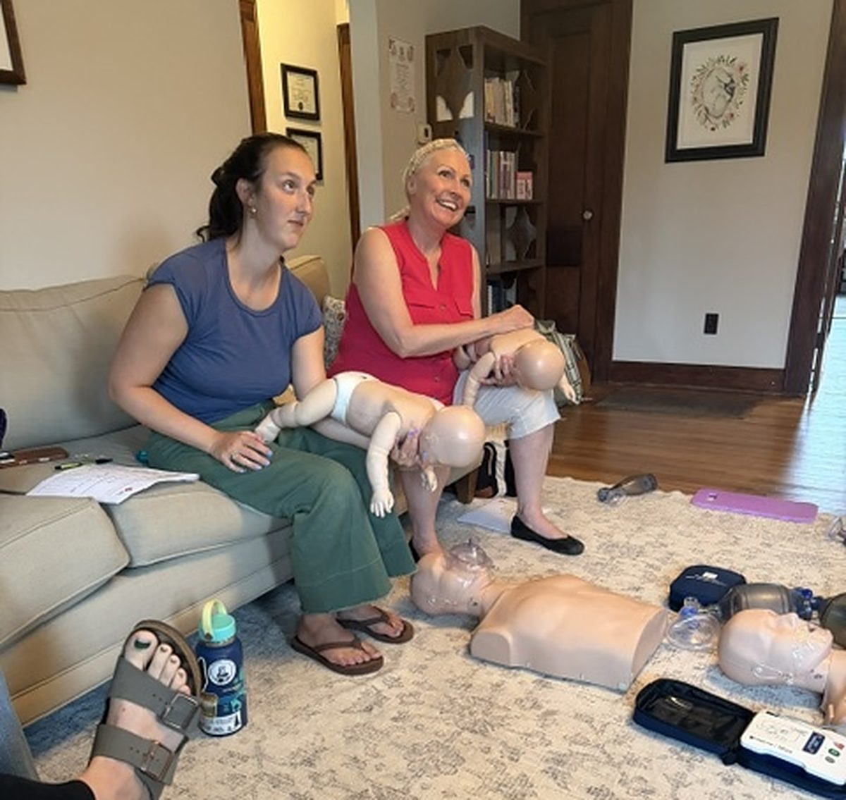 Guests holding infant manikins during a Tiny Hearts CPR party