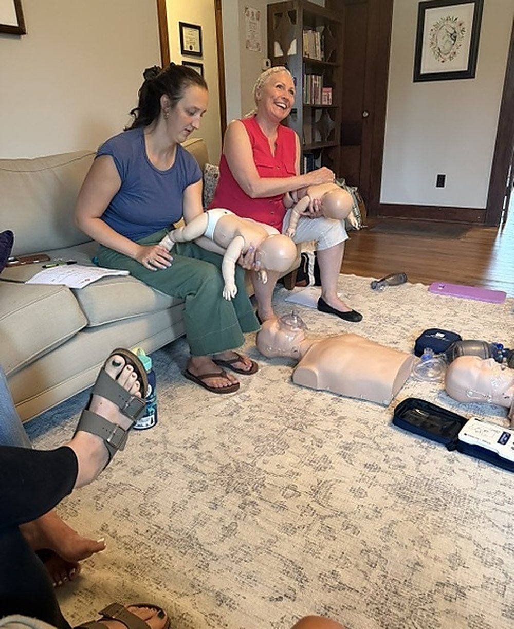 Two guests practicing infant CPR on manikins during a CPR party
